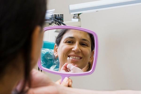 patient looking at cosmetic dental results in mirror 