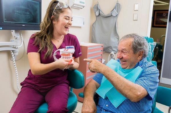 Sstaff member showing tooth model to patient in Philadelphia, PA